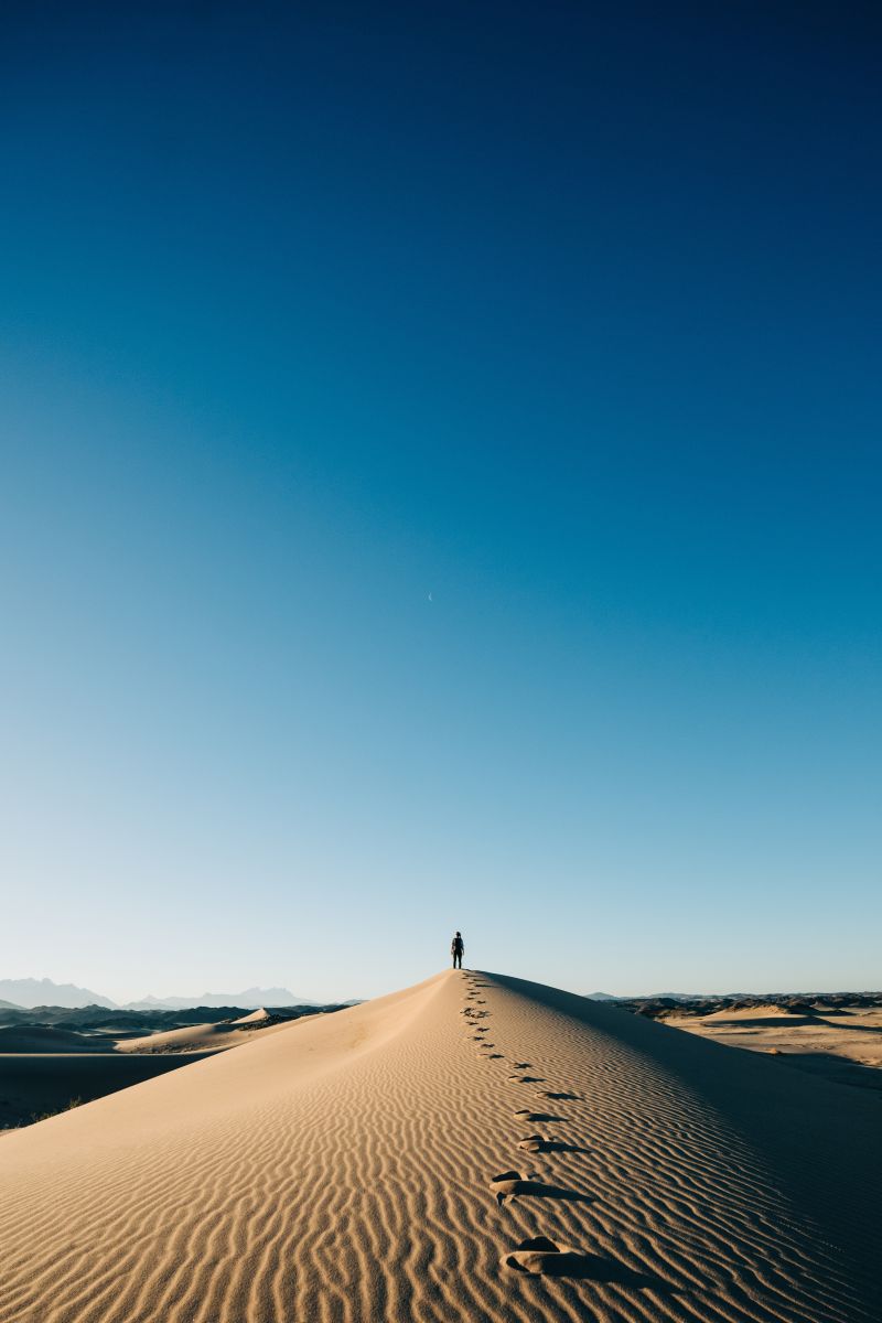 一个人站在一望无际的沙漠